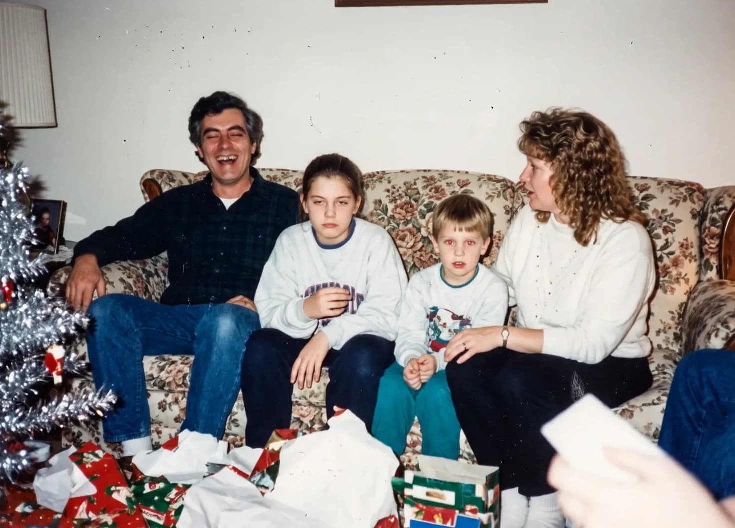 The family of four on a floral couch on Christmas morning