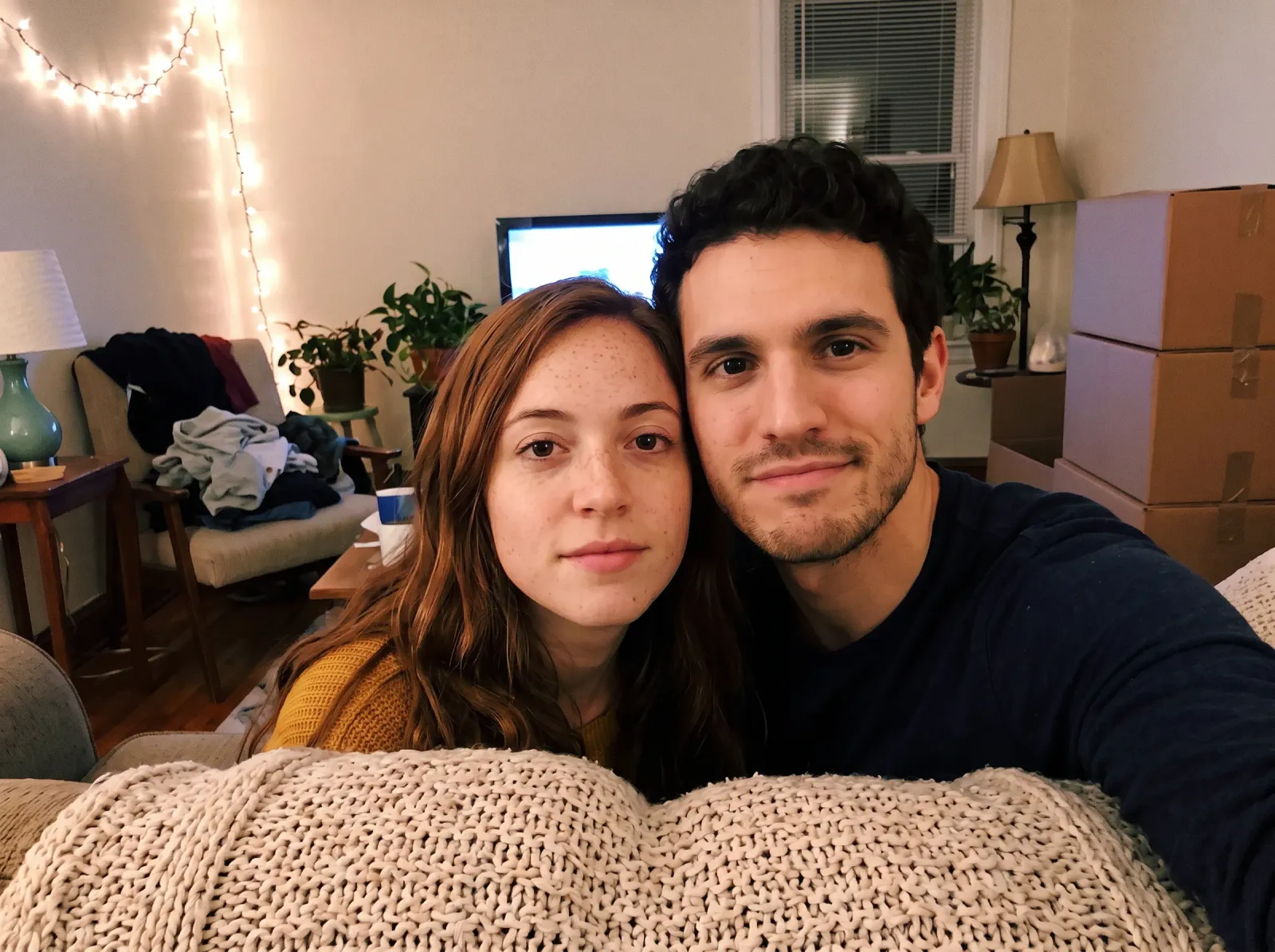 The couple taking a selfie on the couch in their finished living room