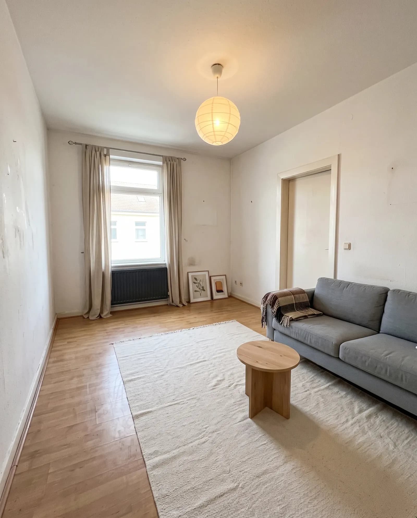 Curtains, a white rug, and a small wooden table added