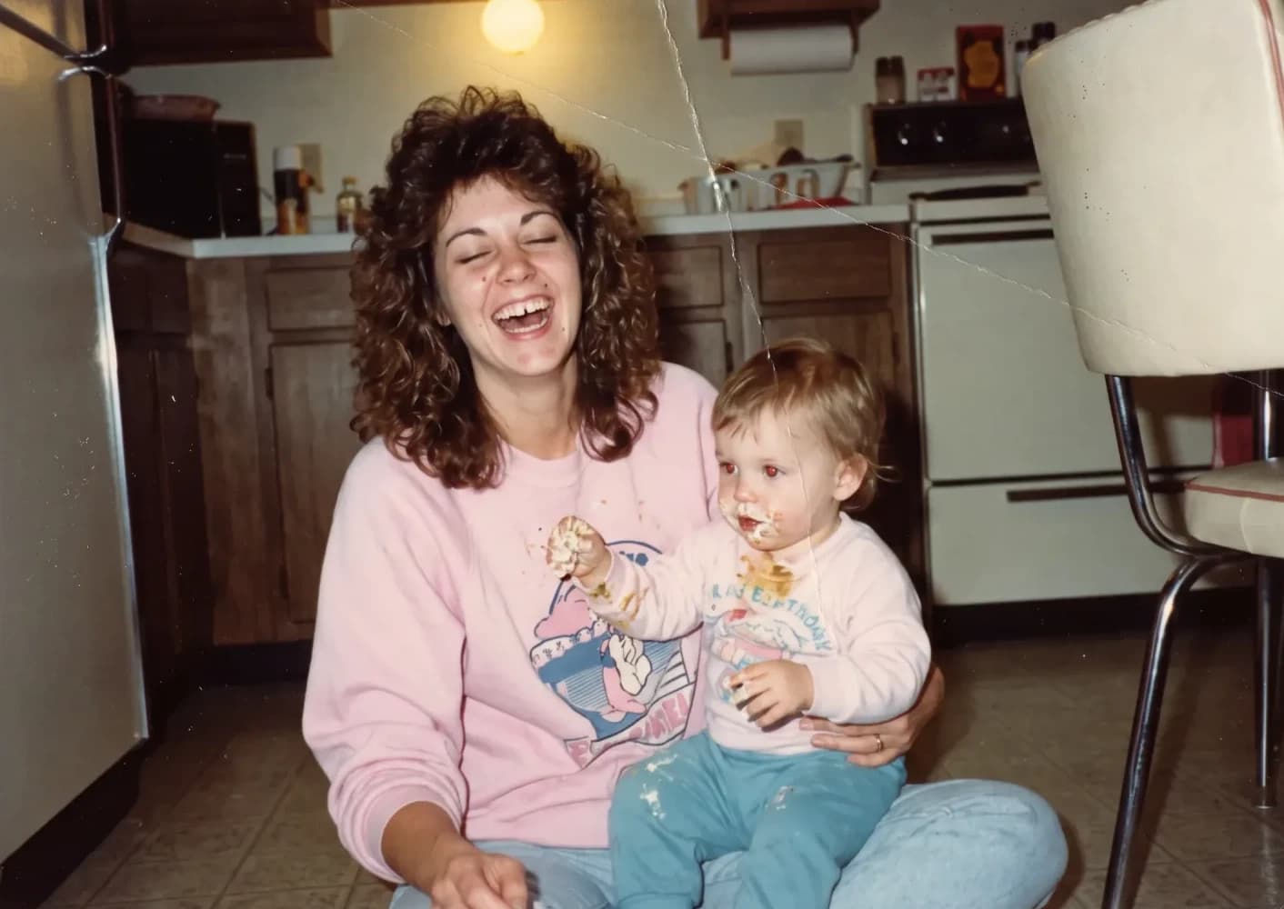 As a young mother, laughing on the kitchen floor with her baby