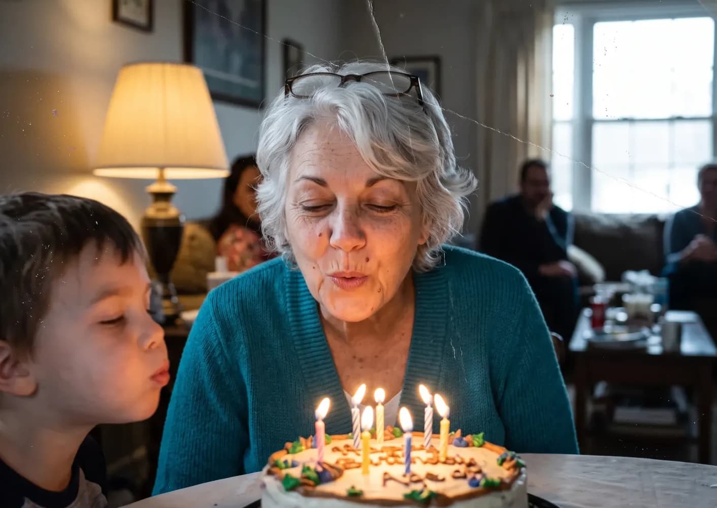 Now gray-haired, blowing out her candles beside her grandson
