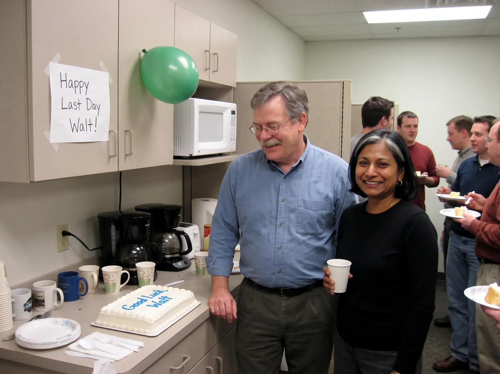 His last day: the pair by a farewell cake under a Happy Last Day sign
